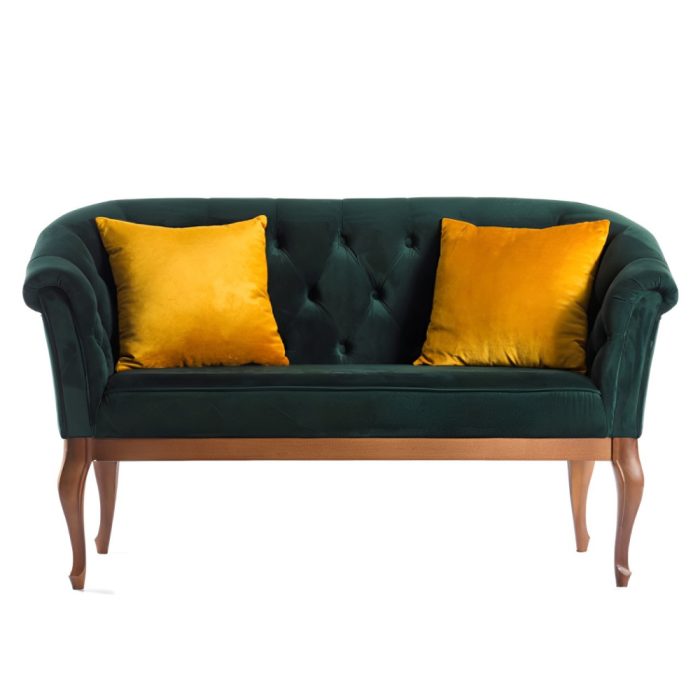 Elegant dark green velvet sofa with deep tufting and two gold cushions, on slender wooden legs.